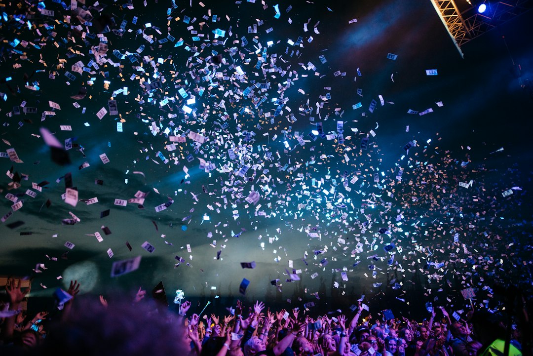 Público celebrando en concierto con confeti